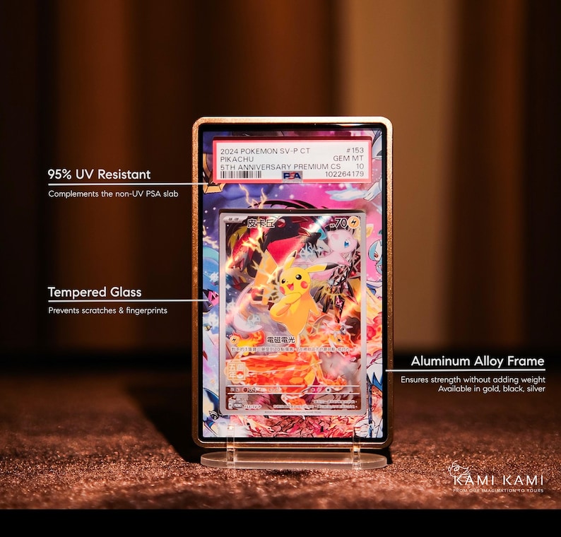 May include: A framed Pok&eacute;mon trading card featuring Pikachu. The card is encased in a gold-colored aluminum alloy frame with tempered glass and 95% UV resistance. The frame is displayed on a clear stand.