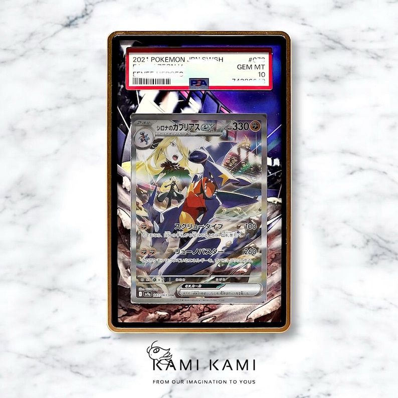 Pu&ograve; includere: Una carta Pok&eacute;mon valutata con un'illustrazione di personaggio e testo giapponese. La carta &egrave; racchiusa in un supporto protettivo con una cornice dorata. Il supporto mostra un'etichetta di certificazione PSA con un grado di 10.