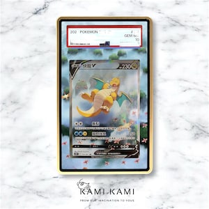 Puede incluir: Una tarjeta coleccionable de Pok&eacute;mon enmarcada con un personaje Dragonite amarillo con alas azules. La tarjeta est&aacute; calificada como GEM MINT 10 y tiene texto japon&eacute;s. El marco es dorado y la tarjeta est&aacute; dentro de una funda protectora transparente.