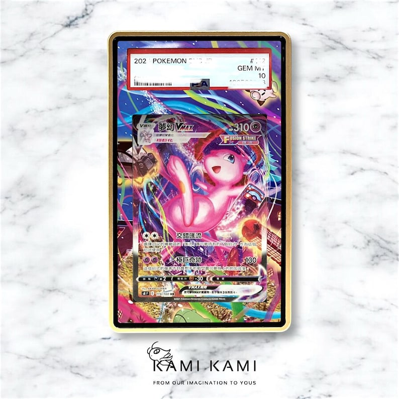 May include: A Pokemon trading card featuring a pink Mew character, graded and encased in a gold-colored frame. The card has Japanese text and the number 202. The card is labeled "GEM M 10". The bottom of the frame has the text "KAMI KAMI".