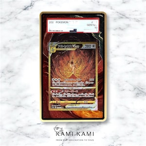 May include: A graded Pok&eacute;mon card featuring the character Arceus VSTAR, with Japanese text. The card is encased in a gold-framed holder with a red and gold background. The card has a GEM M 10 grade.