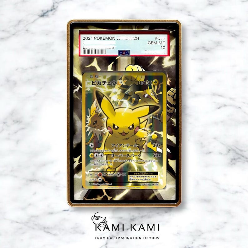 May include: A graded Pok&eacute;mon trading card featuring Pikachu. The card is encased in a gold-colored frame with the text "GEM MT 10". The card has Japanese text and illustrations of Pikachu and other characters.