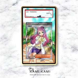 K&ouml;nnte beinhalten: Eine bewertete Pok&eacute;mon-Karte in einem goldfarbenen Rahmen, die eine Charakterillustration mit rosa Haaren und einem wei&szlig;en Mantel zeigt. Die Karte ist mit GEM MINT 10 bewertet. Der Text "202 POKEMON" ist sichtbar.