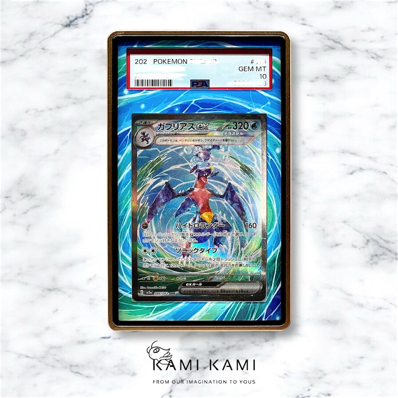 Puede incluir: Una carta de comercio de Pokemon clasificada con un Garchomp azul y rojo con el texto "ガブリアス EX - 320" y "ハイドロランチャー 160" en japon&eacute;s. La carta est&aacute; clasificada GEM MT 10.