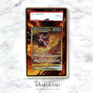 May include: A gold-colored Pokemon trading card encased in a gold frame. The card features a character with pink and white accents against a fiery background. The card is labeled "202 Pokemon" and "GEM MINT 10". The bottom of the frame has the text "KAMI KAMI".