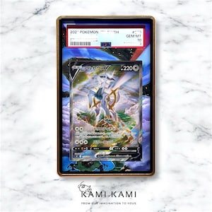 Puede incluir: Una carta coleccionable de Pok&eacute;mon calificada con el personaje Arceus V, con texto en japon&eacute;s. La carta est&aacute; dentro de un soporte protector con un marco dorado. El soporte tiene una calificaci&oacute;n PEA de GEM MT 10.
