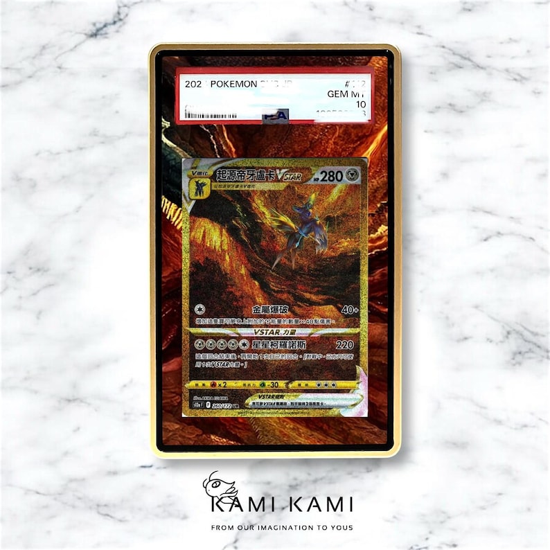 May include: A gold-framed Pok&eacute;mon trading card featuring a gold and brown illustration of a creature with blue and purple accents. The card has Japanese text and a red and white label at the top. The card is graded GEM M 10.