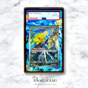 May include: A framed Pok&eacute;mon trading card featuring a yellow Psyduck character and a female trainer. The card is graded GEM MT 10. The frame has a gold border and a blue and white patterned background.