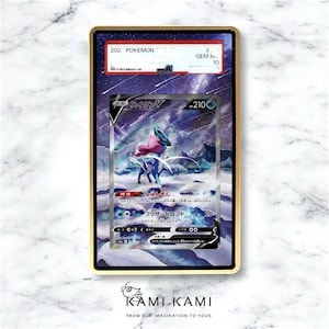 May include: A graded Pok&eacute;mon card featuring Suicune V, encased in a gold-colored frame. The card displays a vibrant illustration of Suicune in a snowy landscape, with Japanese text and a GEM MINT 10 grade.