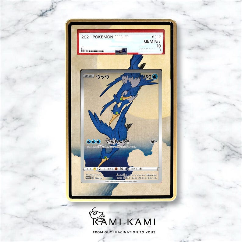 Puede incluir: Una carta Pok&eacute;mon calificada con una ilustraci&oacute;n de p&aacute;jaro azul y texto japon&eacute;s. La carta est&aacute; encapsulada en un marco dorado con una calificaci&oacute;n GEM M 10. El fondo de la carta est&aacute; inspirado en el arte tradicional japon&eacute;s.