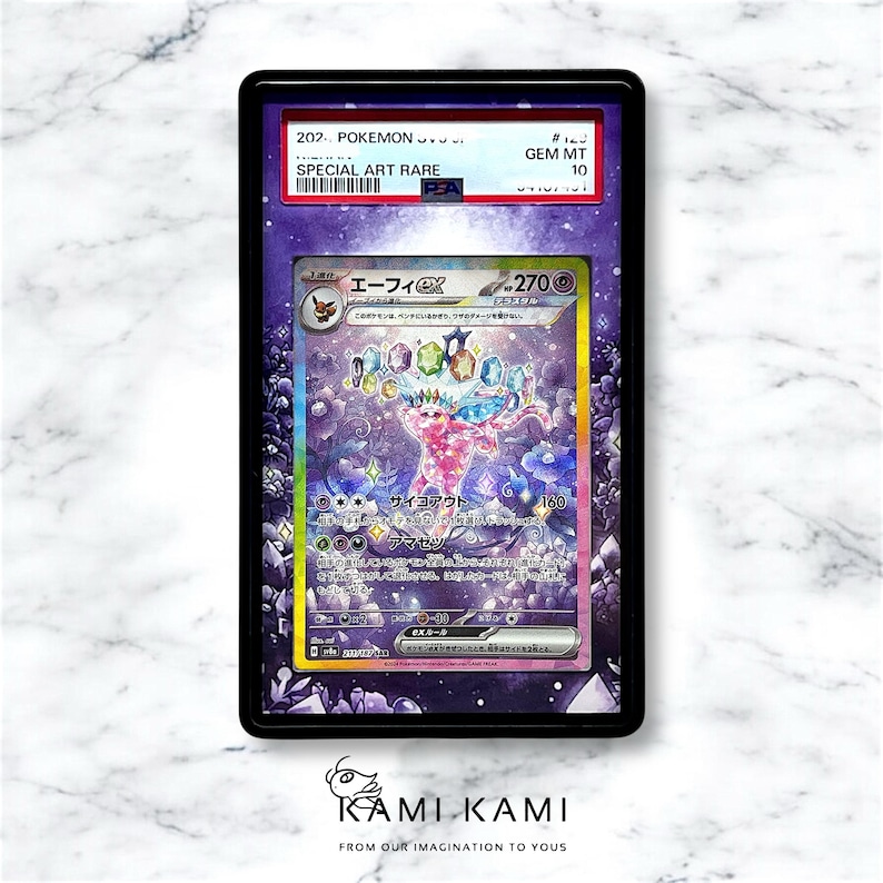 May include: A Pokemon trading card in a black display case. The card has a vibrant illustration of a creature with Japanese text. The top of the case reads "SPECIAL ART RARE" and "GEM MT 10". The bottom of the case has the text "KAMI KAMI".
