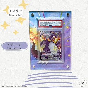 Puede incluir: Una vitrina de acr&iacute;lico transparente con un fondo morado y azul. La vitrina contiene una carta de juego de comercio Pokemon que presenta una carta Charizard VMAX con una calificaci&oacute;n Gem Mint 10. La carta es del set japon&eacute;s Sword and Shield Shiny Star V.
