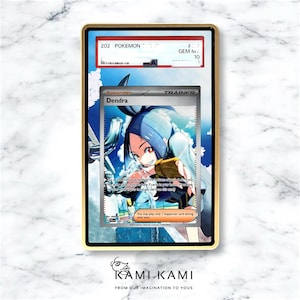 Puede incluir: Una carta de Pok&eacute;mon calificada con el personaje Dendra, enmarcada en dorado. La carta muestra "202 Pok&eacute;mon" y est&aacute; calificada como GEM M 10. La parte inferior de la imagen tiene el texto "KAMI KAMI FROM OUR IMAGINATION TO YOUS."