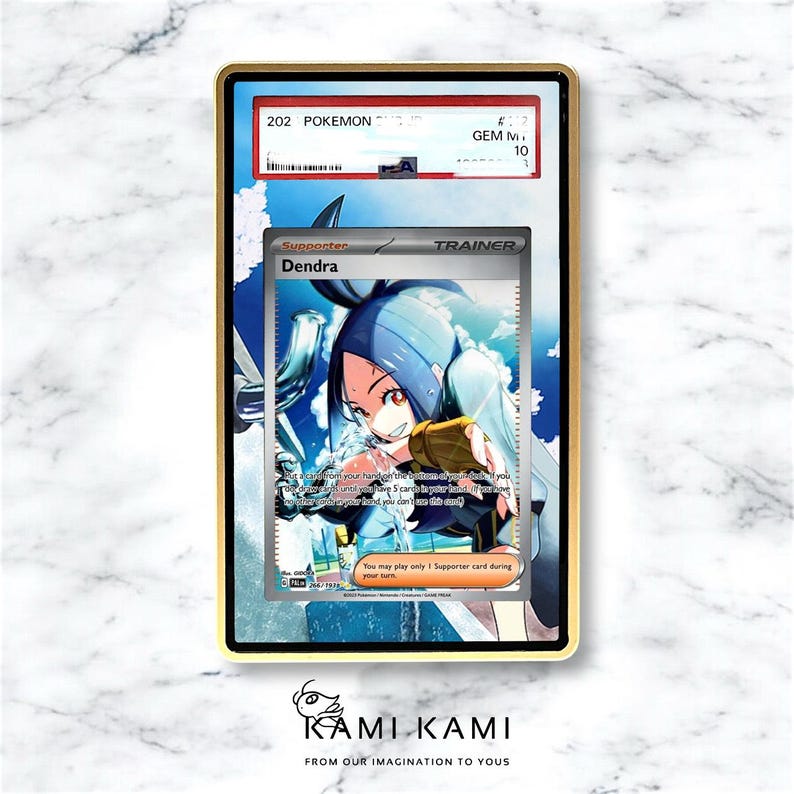 Puede incluir: Una carta de Pok&eacute;mon calificada con el personaje Dendra, enmarcada en dorado. La carta muestra "202 Pok&eacute;mon" y est&aacute; calificada como GEM M 10. La parte inferior de la imagen tiene el texto "KAMI KAMI FROM OUR IMAGINATION TO YOUS."