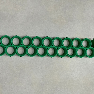 May include: A green plastic battery holder with 18 individual slots for storing batteries.