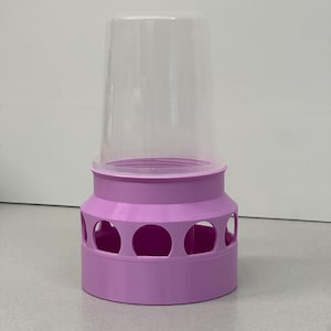 May include: A pink plastic bird feeder with a clear plastic top and multiple openings around the base.
