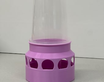 Puede incluir: Un comedero para pájaros de plástico rosa con una tapa de plástico transparente y múltiples aberturas alrededor de la base.