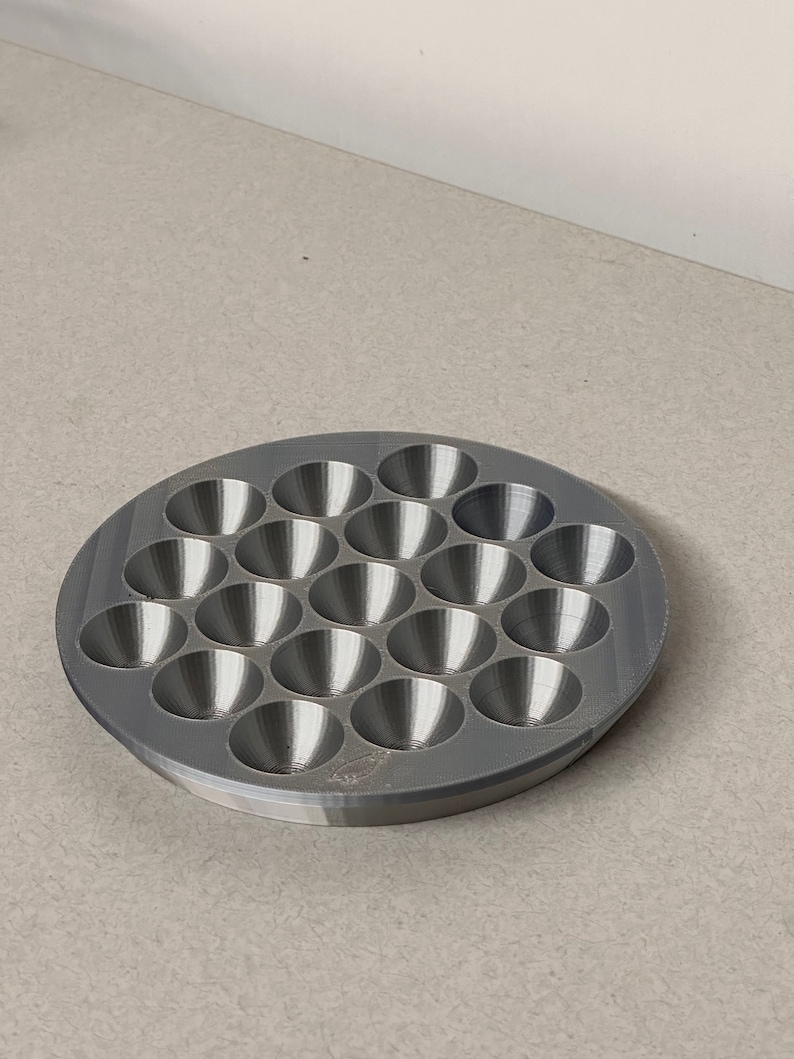 May include: A gray plastic tray with 24 round depressions, perfect for holding small items like beads or buttons.