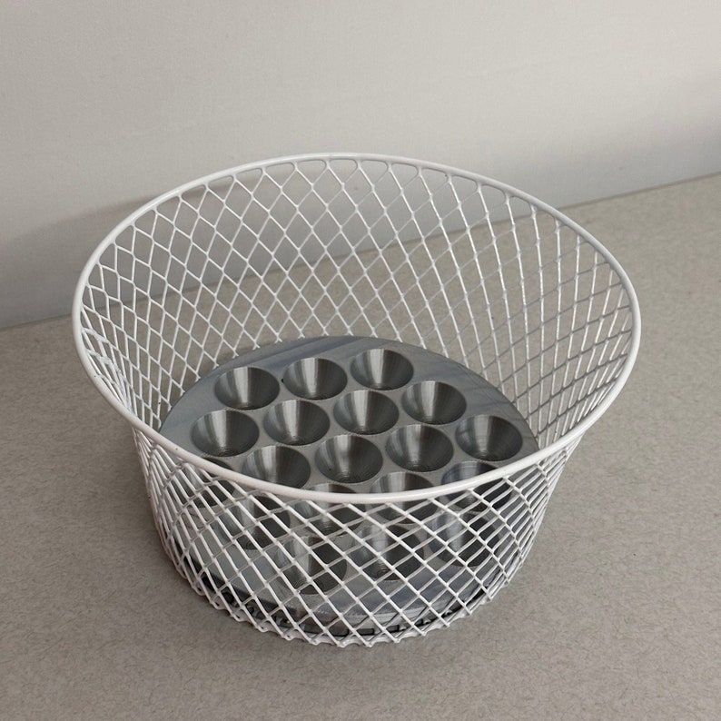 May include: White wire basket with a gray metal insert with 12 round depressions. The basket is ideal for organizing small items.