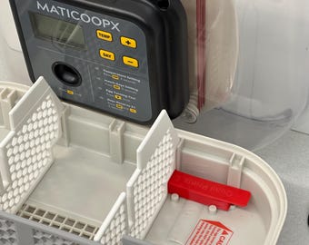 Puede incluir: Una incubadora de huevos de plástico blanco con un panel de control digital etiquetado como "MATICOOOPX". El panel de control tiene botones para la temperatura, el día y el volteo de los huevos. La incubadora tiene una tapa de plástico transparente y una manija de plástico roja.
