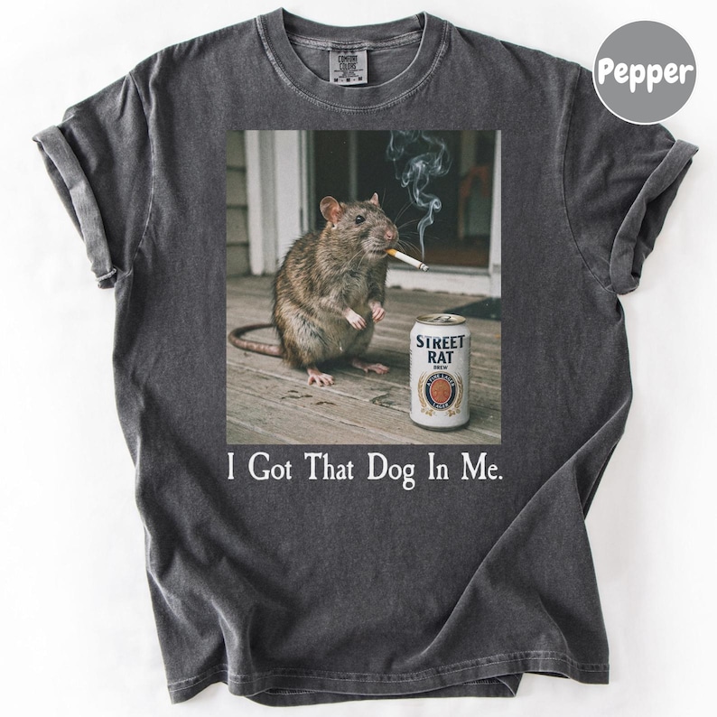 A gray t-shirt with a graphic design depicting a rat smoking a cigarette next to a can of Street Rat beer.