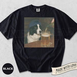 May include: Black t-shirt with a graphic of a dog in a blue cap watching beer being poured into a mug. The image is a humorous take on a bar scene. The shirt has a faded, vintage appearance.