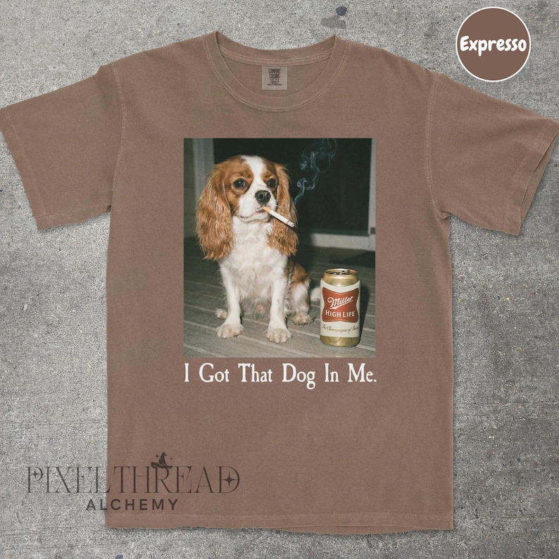 A brown t-shirt with a printed image of a dog holding a can of Miller High Life beer.