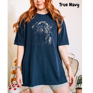 a woman wearing a blue t - shirt with a dog on it