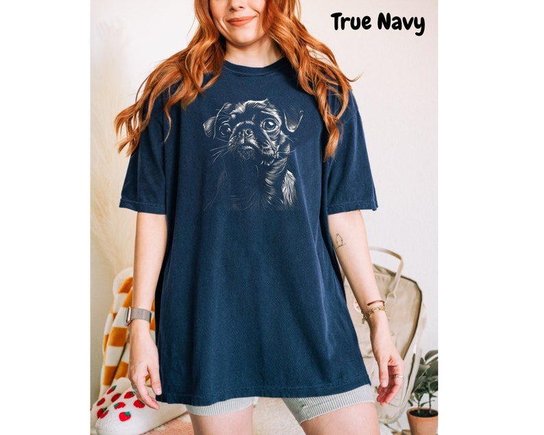 a woman wearing a blue t - shirt with a dog on it