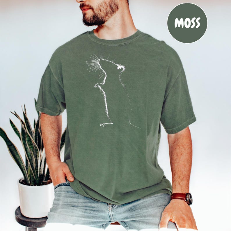 a man wearing a t - shirt with a picture of a cat on it