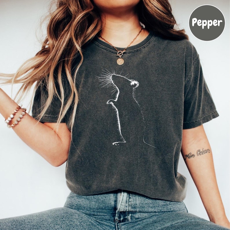 a woman wearing a t - shirt with a dandelion drawing on it