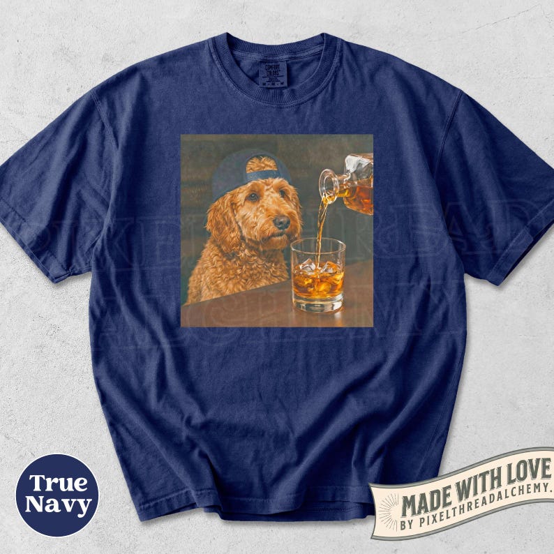 K&ouml;nnte beinhalten: Marineblaues T-Shirt mit einem quadratischen Aufdruck eines Hundes mit Kappe, der beobachtet, wie Whisky in ein Glas mit Eis gegossen wird. Das Shirt tr&auml;gt die Aufschrift "True Navy" und "Made with Love".