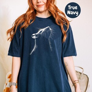 a woman with red hair wearing a blue t - shirt