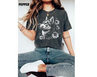 May include: A dark gray t-shirt with a white graphic of a husky dog surrounded by flowers. The dog is looking up and to the right. The shirt is made of a soft, comfortable material.