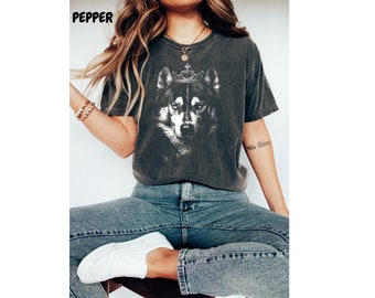 May include: A dark gray t-shirt with a graphic print of a wolf wearing a crown. The wolf is black and white and has a serious expression.