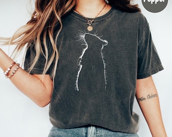 May include: Dark gray t-shirt featuring a white silhouette of a rat. The rat is depicted in profile, looking upwards. The shirt has a vintage, washed appearance. The word "Pepper" is in a circle on the top right.