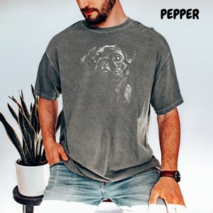 a man wearing a t - shirt with a picture of a dog on it