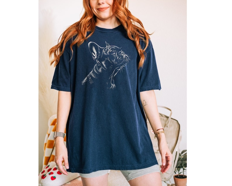 a woman with red hair wearing a blue t - shirt