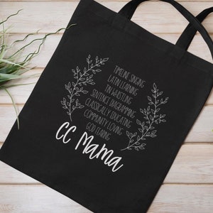 May include: Black tote bag with white text and a floral design. The text reads "TIMELINE SINGING, LATIN LEARNING, IN WHISTLING, SENTENCE DIAGRAMMING, CLASSICALLY EDUCATING, COMMUNITY LOVING, GOD FEARING, CC Mama".