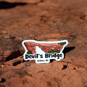 May include: White sticker with a cartoon illustration of Devil's Bridge in Sedona, Arizona. The sticker has the text "Devil's Bridge" and "Sedona, AZ" in black.