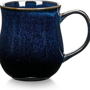 Puede incluir: Una taza de cerámica azul oscuro con un esmalte moteado y un cuerpo redondeado. La taza tiene un asa y es perfecta para disfrutar de una bebida caliente.