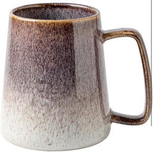 May include: A brown and white ceramic mug with a textured glaze. The mug has a wide base and a handle.