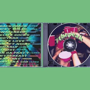 May include: A CD case with a green background. The left side lists song titles like "BACK2BACK" and "ICEY SOLES." The CD itself features a photo of people toasting with red cups, with the text "#thepeak" in green.