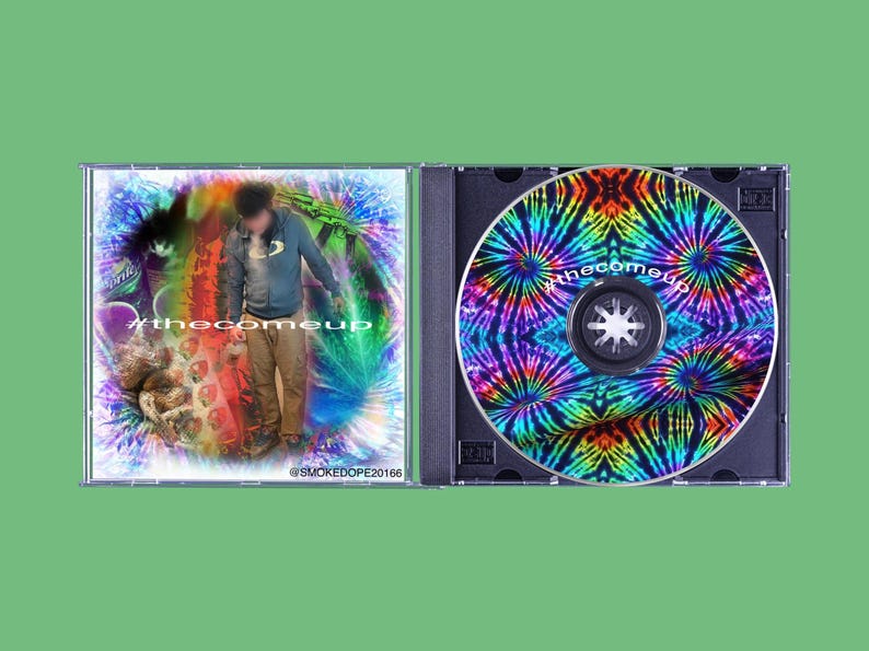 May include: A CD case with a tie-dye design on the disc and cover art featuring a person and the text "#thecomeup". The disc has a black center and the case is open.