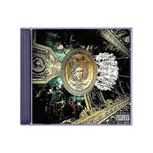 May include: A CD case featuring a gold medallion with a Medusa head on a dark background. The artwork has a classical theme with architectural details and a "Parental Advisory Explicit Content" warning.