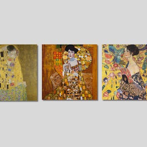 May include: Three paintings in a row, each featuring a different scene from the work of Gustav Klimt. The first painting shows a couple embracing, the second shows a woman in a gold dress, and the third shows a woman in a black dress with a peacock feather.