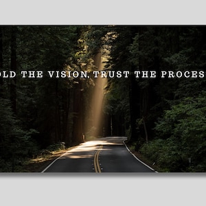Puede incluir: Imagen de una carretera que serpentea a través de un denso bosque, con la luz del sol que atraviesa los árboles. El texto "HOLD THE VISION, TRUST THE PROCESS" se muestra en blanco en la parte superior de la imagen.