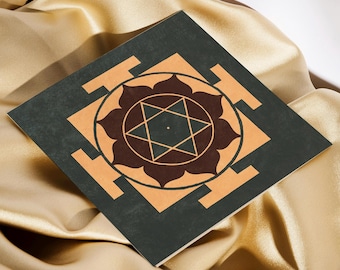 May include: A square, dark green tile with a brown and orange geometric design. The design features a star within a flower shape.