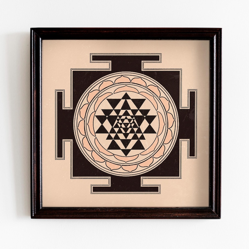 May include: A framed print of a black and white Sri Yantra, a sacred geometric symbol in Hinduism, with a peach-colored background.