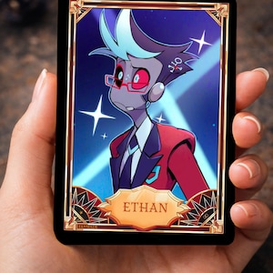 Peut inclure: Une carte à collectionner rectangulaire représentant un personnage de dessin animé à la peau grise, portant des lunettes rouges et une veste de costume rouge. La carte a une bordure dorée, un fond bleu avec des étoiles blanches et une plaque dorée en bas indiquant ETHAN.